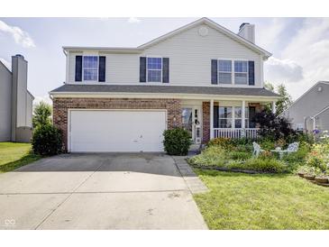 Charming two-story home features a brick accent, attached garage, inviting porch and well-manicured lawn at 2359 Seattle Slew Dr, Indianapolis, IN 46234