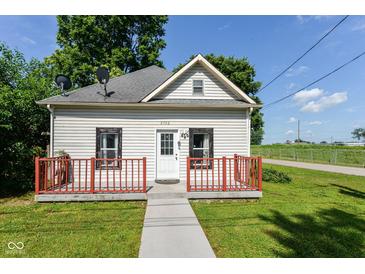Charming one-story home with a red porch, a well-maintained lawn, and classic architectural details at 2702 S Moreland Ave, Indianapolis, IN 46241