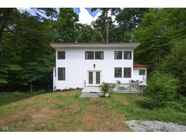 Charming two-story home with a white exterior, front deck, and surrounded by lush trees at 8167 Center Lake Rd, Nineveh, IN 46164
