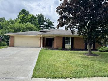Charming one-story brick home with a well-maintained lawn and concrete driveway at 9621 Gemini Dr, Indianapolis, IN 46229