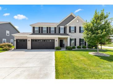 Beautiful two-story home boasts a three-car garage and manicured lawn at 9986 Gallop Ln, Fishers, IN 46040