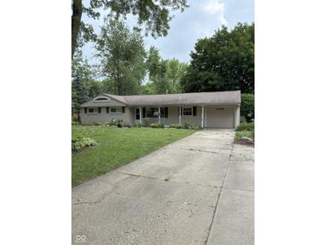 Charming single-story home with an attached garage and a well-manicured lawn at 10155 Orchard Park W Dr, Carmel, IN 46280
