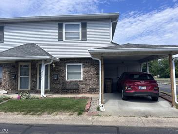 Charming two-story home with carport, landscaped yard, and brick accents at 2080 Miracle Dr, Columbus, IN 47201
