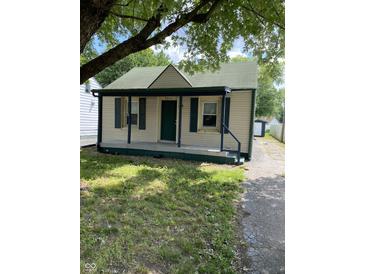 Charming single-story home featuring a covered front porch, green shutters, and a well-maintained lawn at 3059 5Th E Ave, Indianapolis, IN 46221