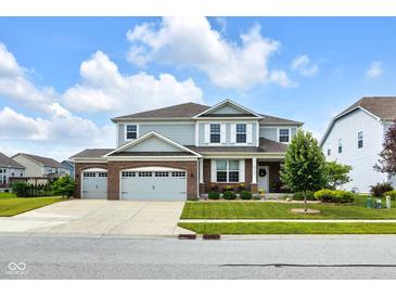 Charming two-story home features a three-car garage and professionally landscaped front yard at 6137 Hardwick Dr, Whitestown, IN 46075