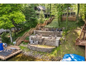 Multi-level backyard with stone patio, and ample seating provides stunning views of the lakefront home at 7082 Muskrat Dr, Nineveh, IN 46164