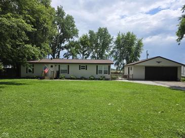 Charming single-story home featuring a spacious green lawn and detached garage at 105 Cottonwood Dr, Maxwell, IN 46154
