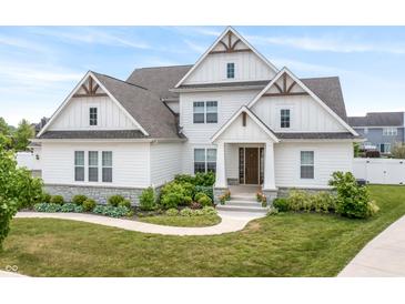 Charming two story home featuring a concrete walkway surrounded by lush landscaping at 10795 Creekbed Cir, Fishers, IN 46038