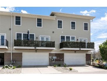 Modern townhome exterior with balconies, two-car garage and neutral siding at 12838 Bird Cage, Carmel, IN 46032