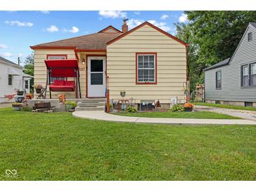 Charming bungalow with a well-maintained lawn, sidewalk and a welcoming front porch swing at 2017 E Legrande Ave, Indianapolis, IN 46203