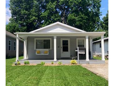 Charming home with a covered front porch, a swing, well-manicured lawn, and appealing curb appeal at 2822 Tindall St, Indianapolis, IN 46203