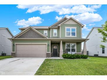 Charming two-story home featuring a well-manicured lawn and attached two-car garage, with a quaint front porch at 1460 Boots Trl, Greenfield, IN 46140