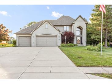 Beautiful two-story brick home with a three-car garage and well-manicured lawn on a sunny day at 2320 Whispering Way, Indianapolis, IN 46239