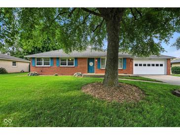 Charming brick ranch-style home with blue shutters, two-car garage, and mature trees at 3504 White River Ct, Anderson, IN 46012
