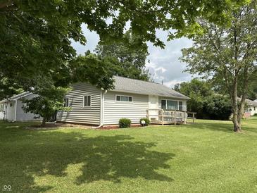 Charming single-story home with a lush lawn, a small front porch, and mature trees providing shade at 411 N 18Th St, Noblesville, IN 46060