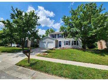 Charming two-story home featuring a well-maintained lawn, attached garage, and inviting curb appeal at 4536 Clayburn Dr, Indianapolis, IN 46268