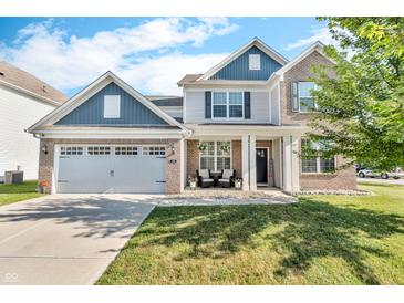 Charming two-story home with brick and siding exterior, complemented by a well-manicured lawn and attached garage at 5353 Hibiscus Dr, Plainfield, IN 46168