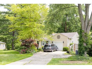 Charming beige home with a one car garage and a well-maintained lawn at 6379 Monitor Dr, Indianapolis, IN 46220