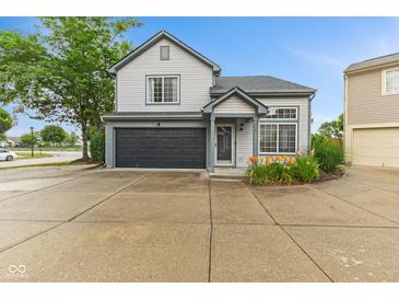 Charming two-story home with a dark garage door, neutral siding and well-manicured landscaping at 772 Cembra Dr, Greenwood, IN 46143