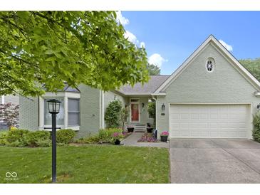 Charming one-story home with a brick facade, attached garage, and beautifully landscaped front yard at 1114 Clairborne Ct, Indianapolis, IN 46280