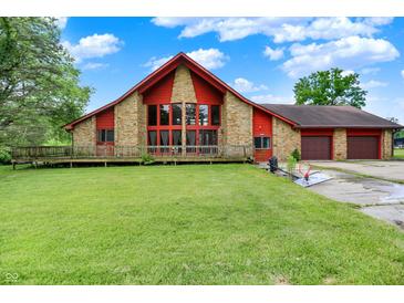 Charming home featuring stone accents, a two-car garage, and a spacious front yard at 13151 W Youth Camp Rd, Columbus, IN 47201