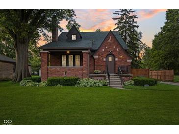 Charming brick home with a well-manicured lawn and inviting front porch at 1420 E Loretta Dr, Indianapolis, IN 46227