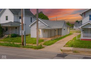 Charming single-story home featuring a welcoming front porch and well-maintained lawn at sunset at 2111 Central Ave, Anderson, IN 46016
