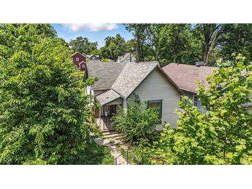 Charming home with a welcoming front porch, surrounded by lush greenery and mature trees at 2426 Lasalle St, Indianapolis, IN 46218