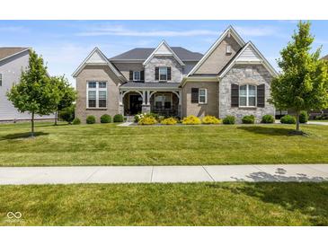 Charming two-story home featuring stone accents, a landscaped yard, and inviting front porch at 2566 Maple Creek Dr, Westfield, IN 46074
