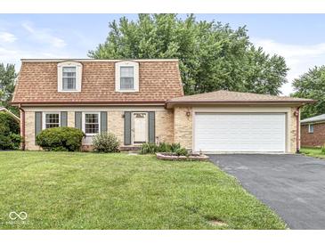 Charming brick home featuring a well-maintained lawn and two-car attached garage at 3224 Prague Rd, Indianapolis, IN 46227