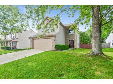 Charming two-story home featuring manicured front lawn, attached garage, and inviting curb appeal at 5541 Lippan Way, Indianapolis, IN 46221
