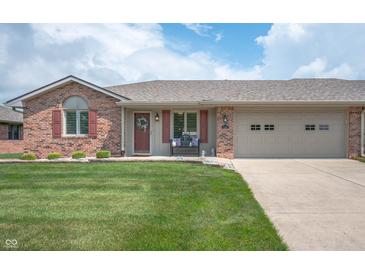 Charming single-story brick home featuring a well-maintained lawn and attached two-car garage at 114 Asbury Dr, Anderson, IN 46013