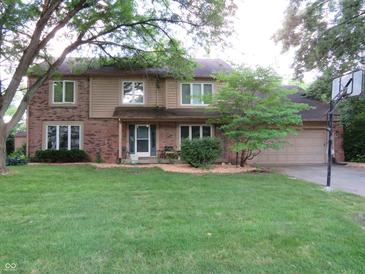 Charming two-story home with a brick facade, well-maintained lawn, and mature trees at 1327 Goldfinch Dr, Carmel, IN 46032