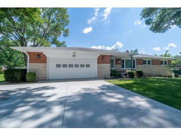 Charming single-story home with a manicured lawn, a long driveway, and an attached garage at 37 E Waterbury Rd, Indianapolis, IN 46227