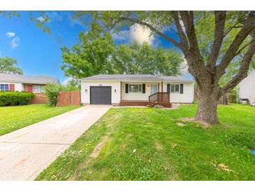 Charming single-story home featuring a well-maintained lawn, attached garage, and inviting front porch at 5512 Lunsford Dr, Indianapolis, IN 46237