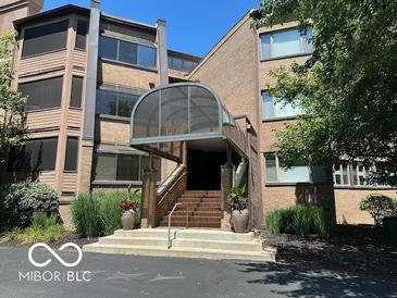 Well-maintained condo building with elegant covered entrance and manicured landscaping at 8577 One W Dr # 301, Indianapolis, IN 46260