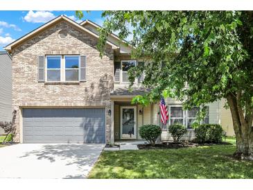 Charming two-story home featuring a well-maintained lawn and a gray two-car garage at 14373 Orange Blossom Trl, Fishers, IN 46038