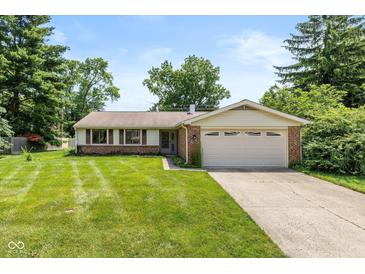 Charming single-story home with a well-manicured lawn and attached two-car garage at 6623 Lakeknoll Dr, Indianapolis, IN 46220