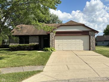 Charming single-story home with a two-car garage, stone accents, and a well-manicured lawn at 7313 Shanna Cir, Indianapolis, IN 46236