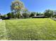 Expansive backyard featuring lush green lawn, mature trees, and a charming single-story home at 2892 S State Road 267, Plainfield, IN 46168