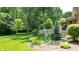 Landscaped backyard with a deck and access to a wooded area at 4738 Moss Creek Ct, Indianapolis, IN 46237