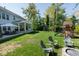 Lush backyard with a covered patio, outdoor seating, play set, and a well-manicured lawn for recreation at 8722 Rockwood Ln, Indianapolis, IN 46259