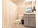 Cozy bathroom with a vanity, toilet, and shower with striped curtain at 8722 Rockwood Ln, Indianapolis, IN 46259