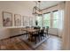 Bright dining room with a long wooden table, black chairs, and large windows with white curtains at 8722 Rockwood Ln, Indianapolis, IN 46259