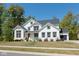 Beautiful two-story white home with dark trim, professional landscaping, and black shingle roof at 8722 Rockwood Ln, Indianapolis, IN 46259