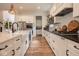 Modern kitchen with white cabinets, stainless steel appliances, a large island and wood flooring at 8722 Rockwood Ln, Indianapolis, IN 46259