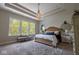 Serene main bedroom with tray ceiling, large windows, and elegant chandelier for a relaxing retreat at 8722 Rockwood Ln, Indianapolis, IN 46259