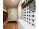 Practical mud room with built-in storage lockers, bench seating, and black and white checkered wallpaper at 8722 Rockwood Ln, Indianapolis, IN 46259