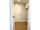 A bright white door leads to a side laundry room with wood-look flooring and white cabinets at 1327 Blue Ridge Ln, Brownsburg, IN 46112