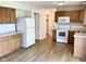 Spacious kitchen with wooden cabinets, white appliances, and laminate flooring at 1327 Blue Ridge Ln, Brownsburg, IN 46112